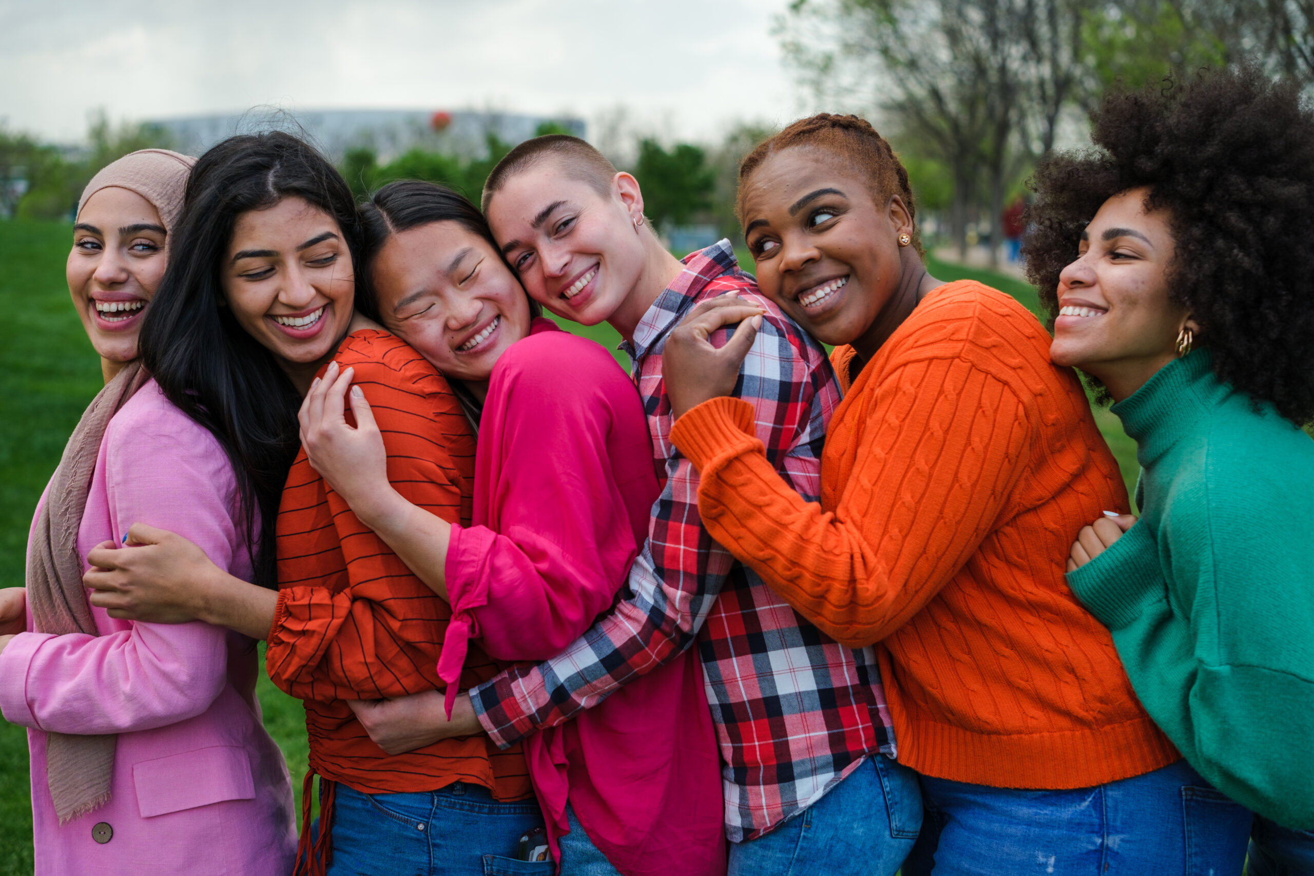 un gruppo di ragazze di diversa etnia si abbracciano felici